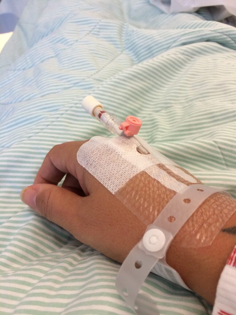 journaling for healing, close up of hand with IV in hospital bed